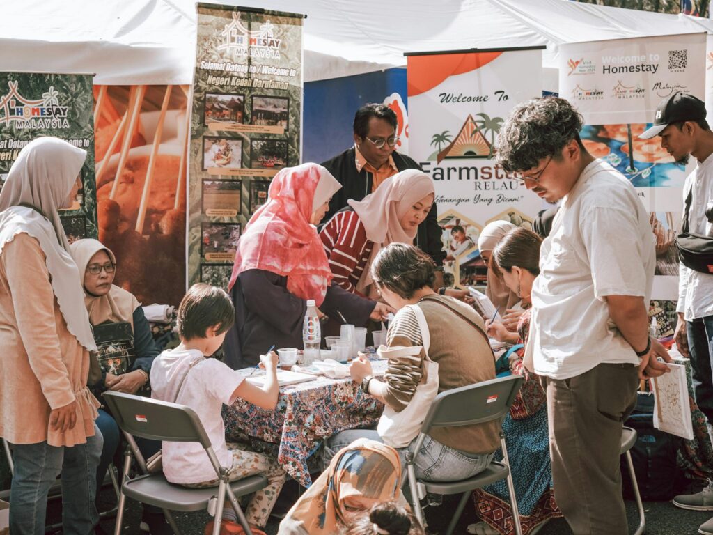 A diverse group of people engaged in activities at a cultural festival booth.