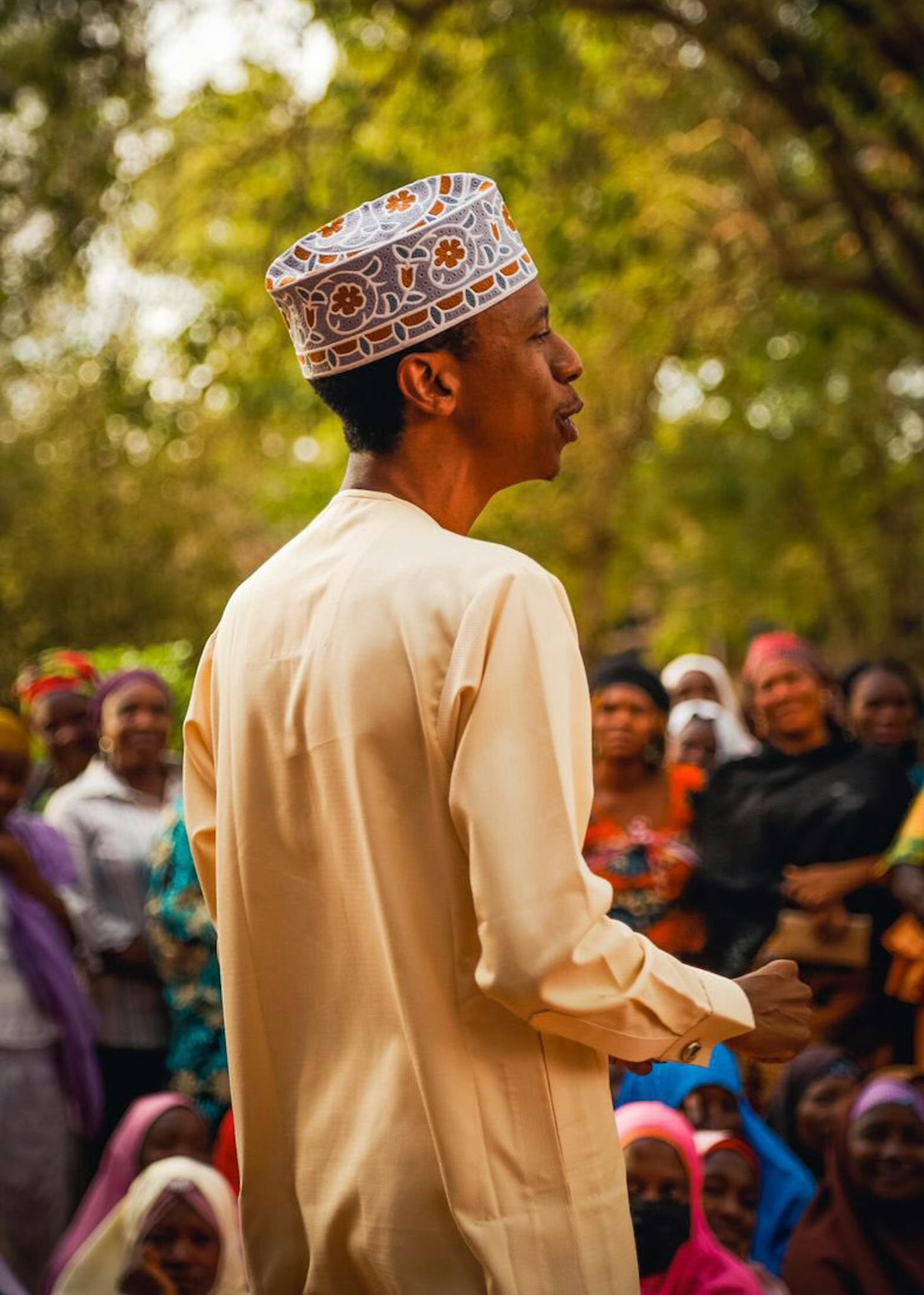 A man leads a community gathering in Kaduna, Nigeria, fostering engagement and unity.